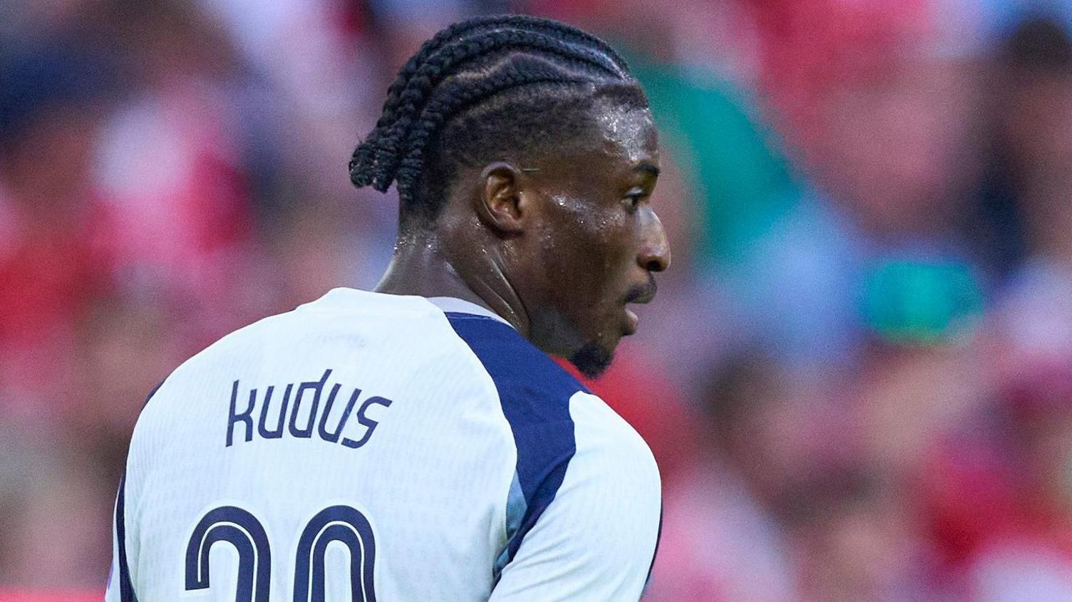 Kudos mohammed punotetuilla hiuksilla näyttää oikealta, koska häntä on kuvattu takaa valkoisessa Tottenham -paidassa, jolla on sininen olkalaji, nimellä ja puolet hänen numerostaan 20, joka on näkyvissä pakkauksensa takana