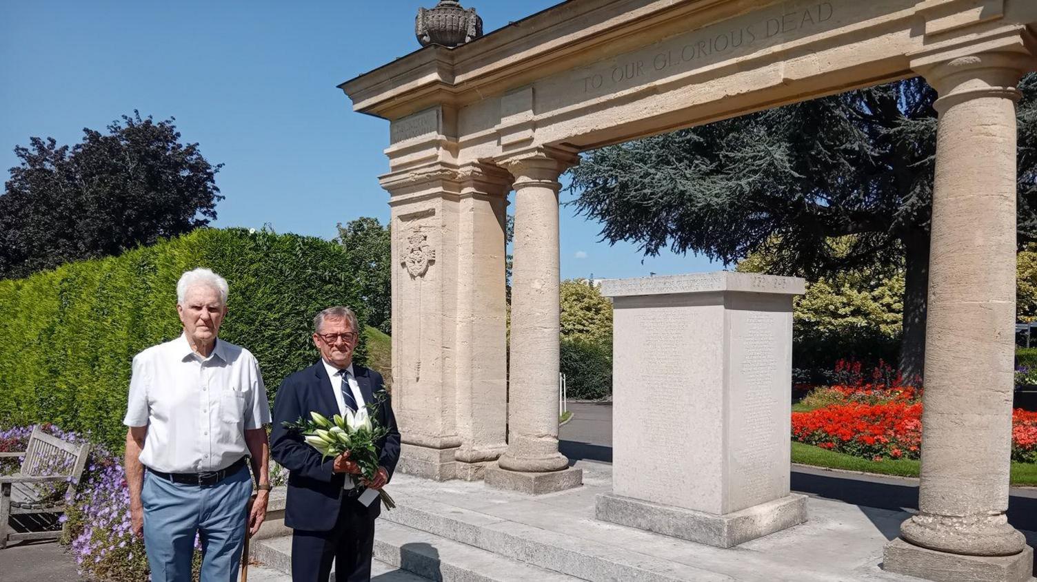 Armed Forces Champion, Councillor Stephen Hives, with Graham Chilton, secretary of the Surrey Branch of Malaya and Borneo Veterans Association on 80th anniversary of VJ Day at Guildford Castle war memorial. Mr Hives is holding white lilies. 
