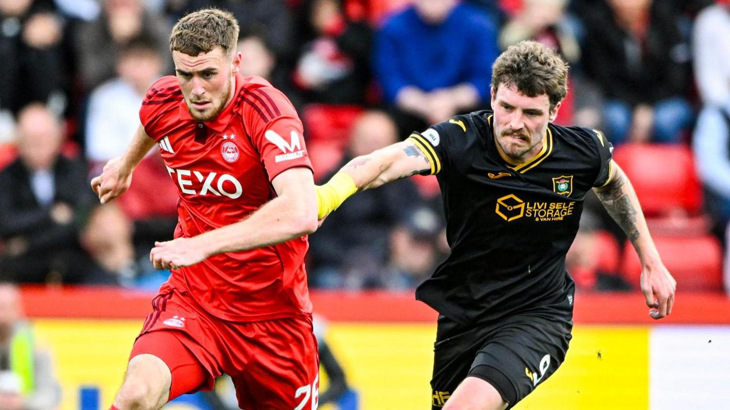 Aberdeen's Alfie Dorrington and Livingston's Robbie Muirhead battle for possession