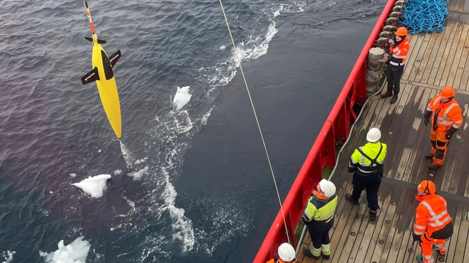 A sea glider being winched from the sea by a team on board the RRS Sir David Attenborough