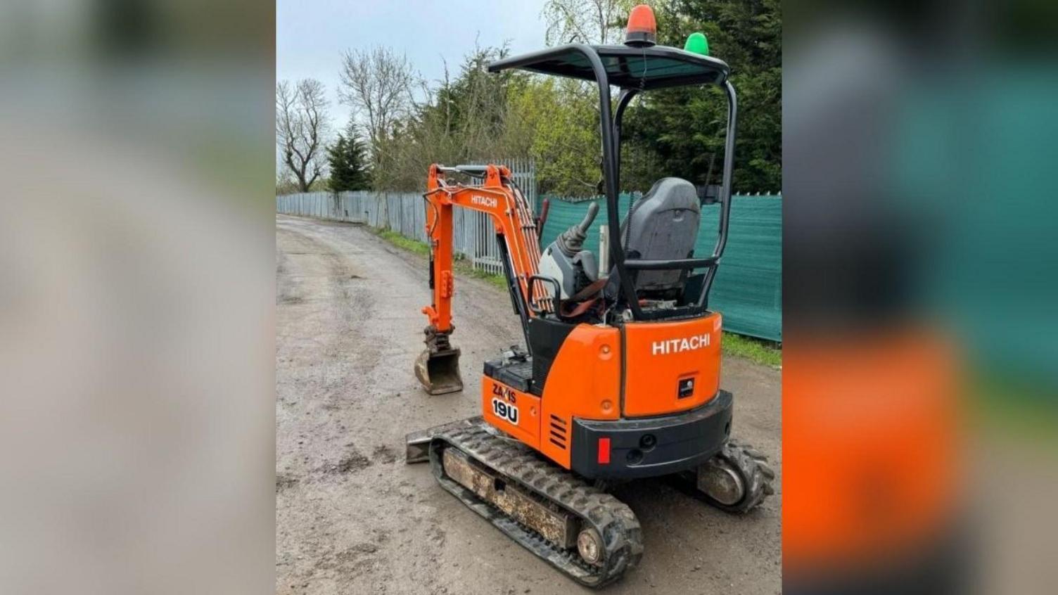 An orange digger on a dirt track. There is no driver in it