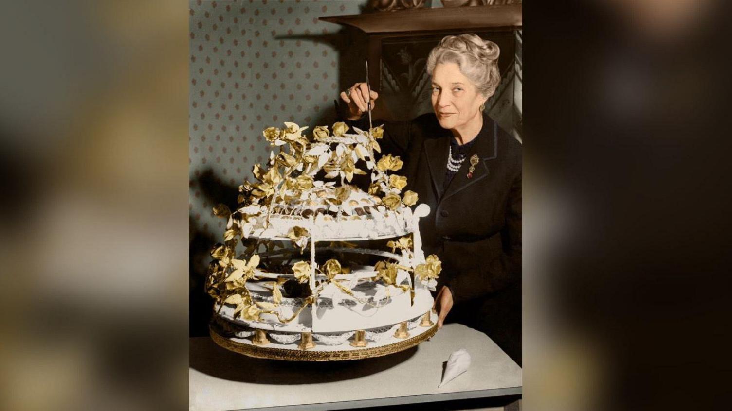 A woman poses by by a circular cake for Winston Churchill