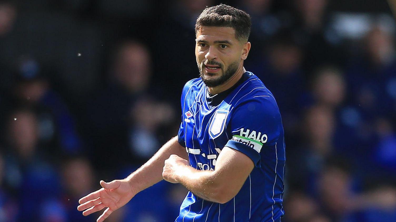 Sam Morsy holding his right arm out with his palm open during a match while playing for Ipswich