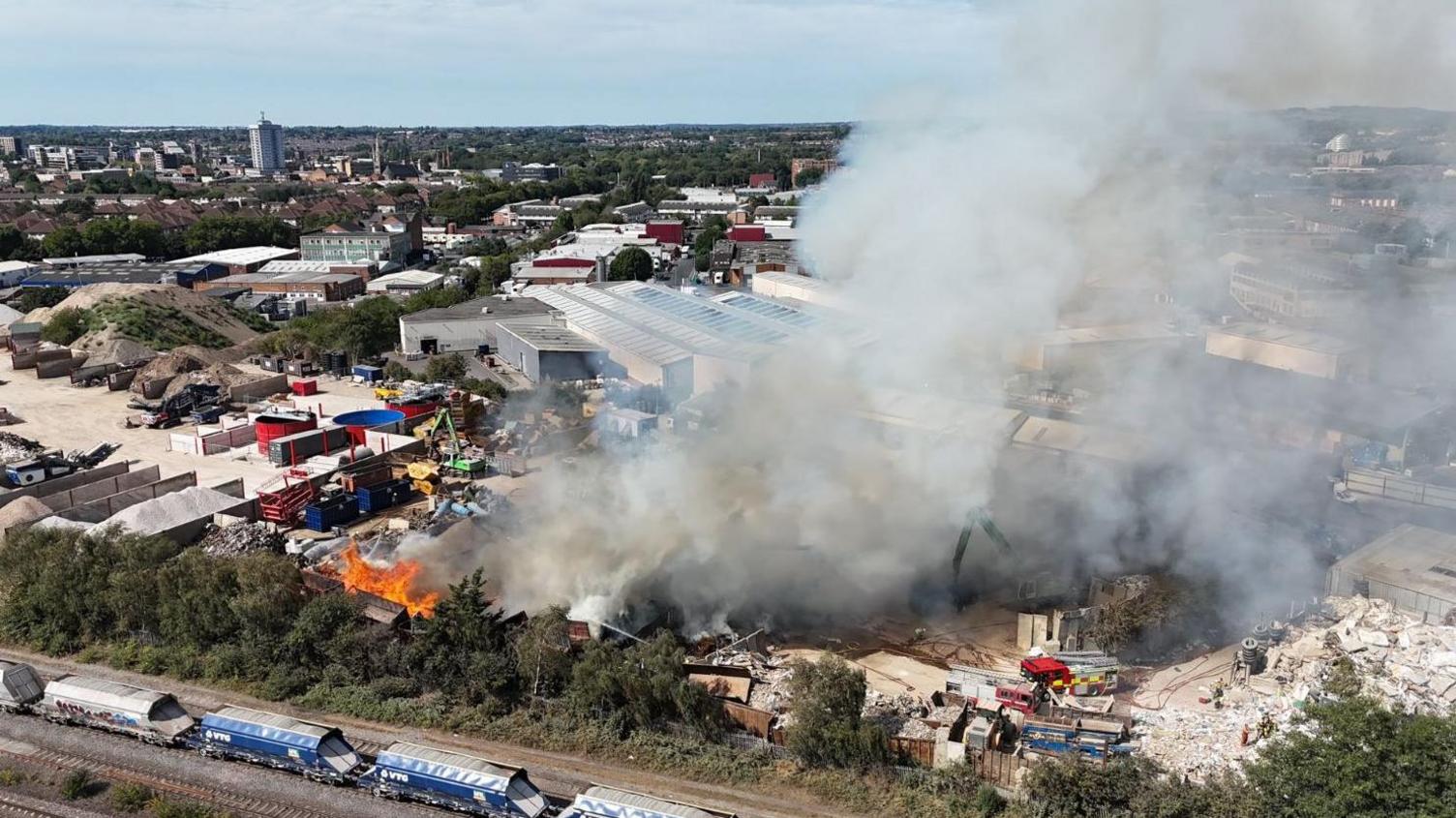 Drone shot of flames and smoke coming from a industrial yard