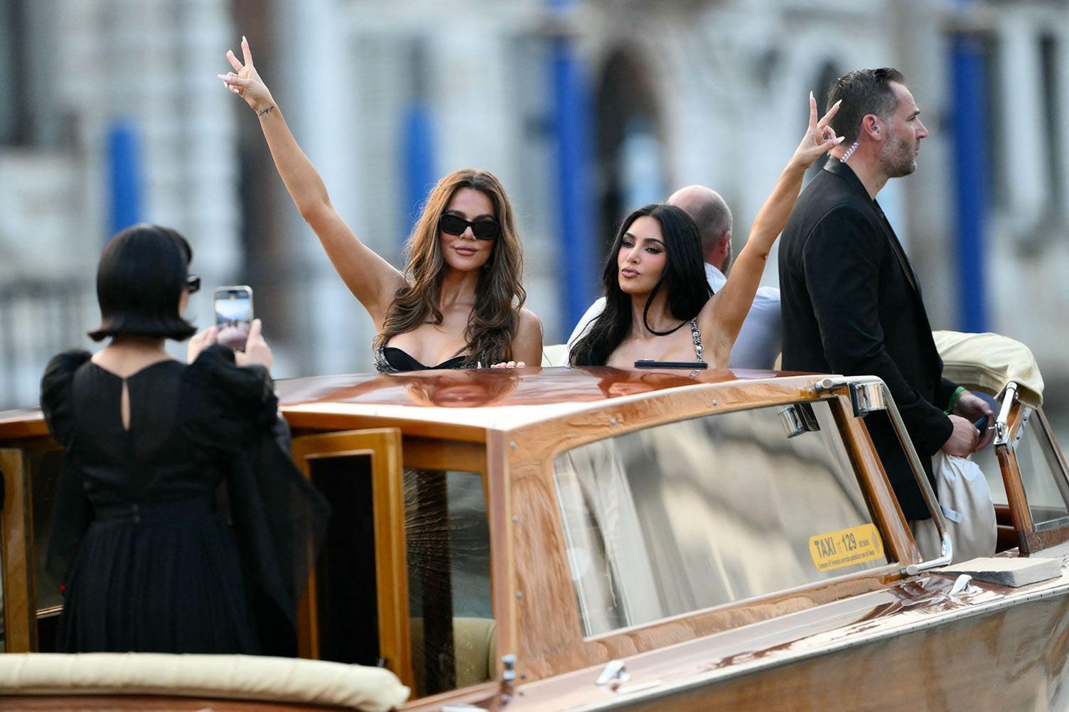 Kris Jenner, Khloe Kardashian and Kim Kardashian in Venice, Italy, for the wedding of Jeff Bezos and Lauren Sanchez. They are gesturing peace signs on a taxi boat while their mother Kris Jenner photographs them.