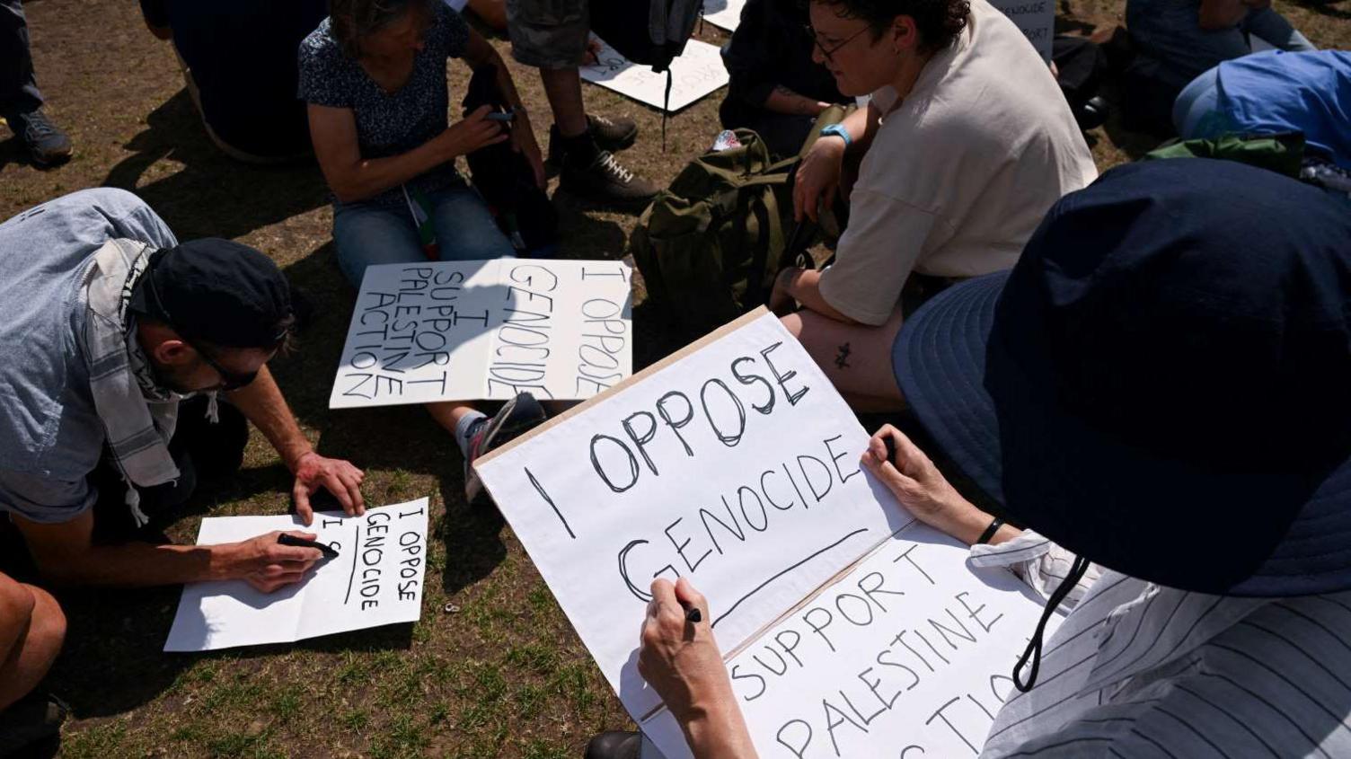 People prepare signs at a protest against the ban of Palestine Action