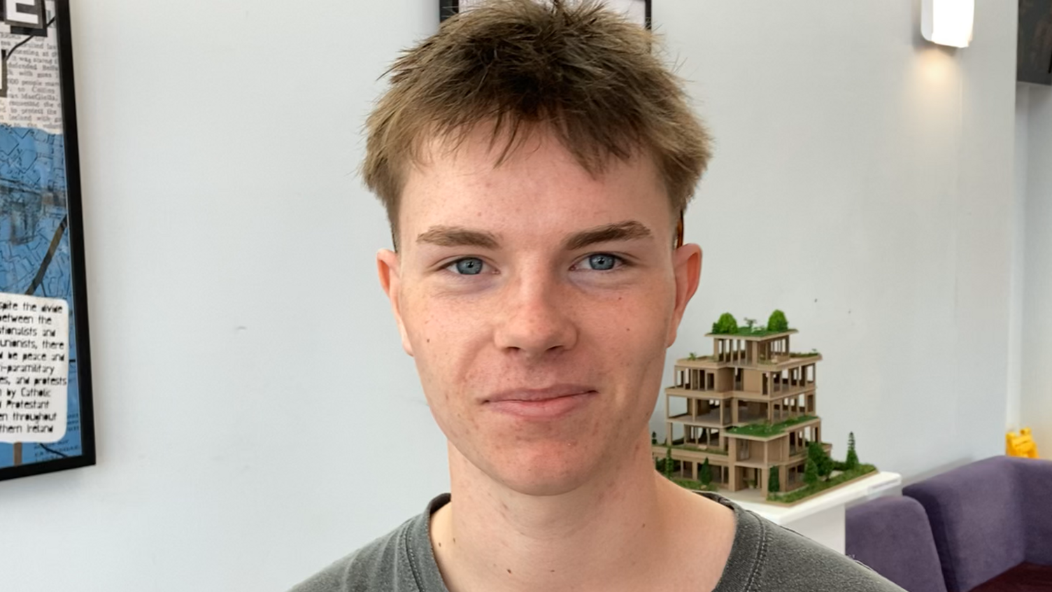 Toby Groom, who has short brown hair and is wearing a green t-shirt, smiles at the camera