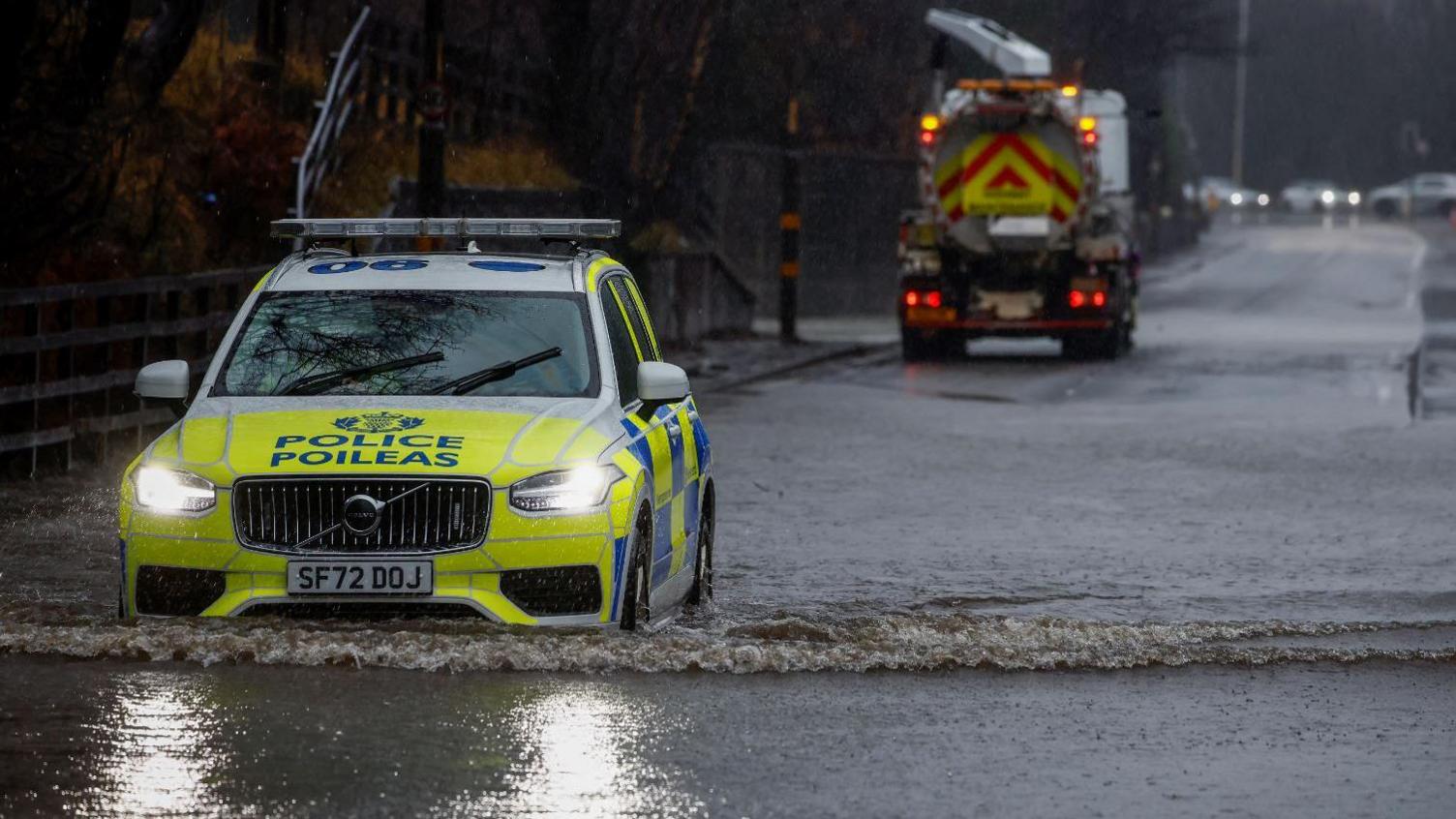 A police car drives through a flooded road in the west end of Glasgow