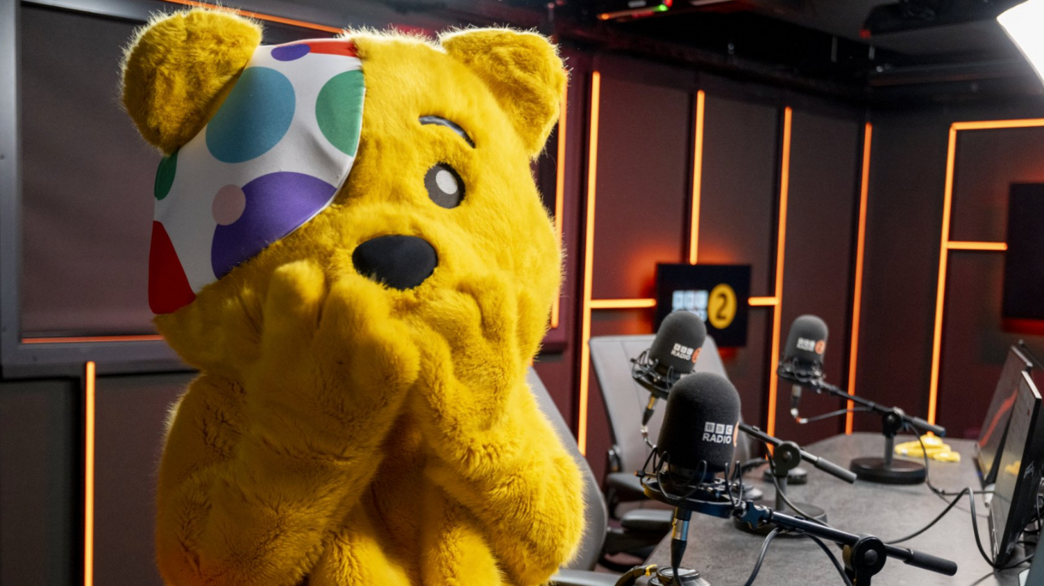 Pudsey bear shown sitting in a radio studio 
