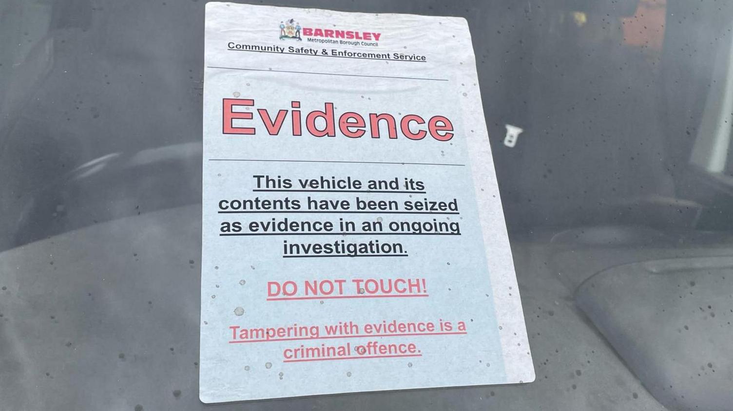 A label on the front window of a van reads: 'Barnsley Council: Evidence. This vehicle and its contents have been seized as evidence in an ongoing investigation. Do Not Touch!"