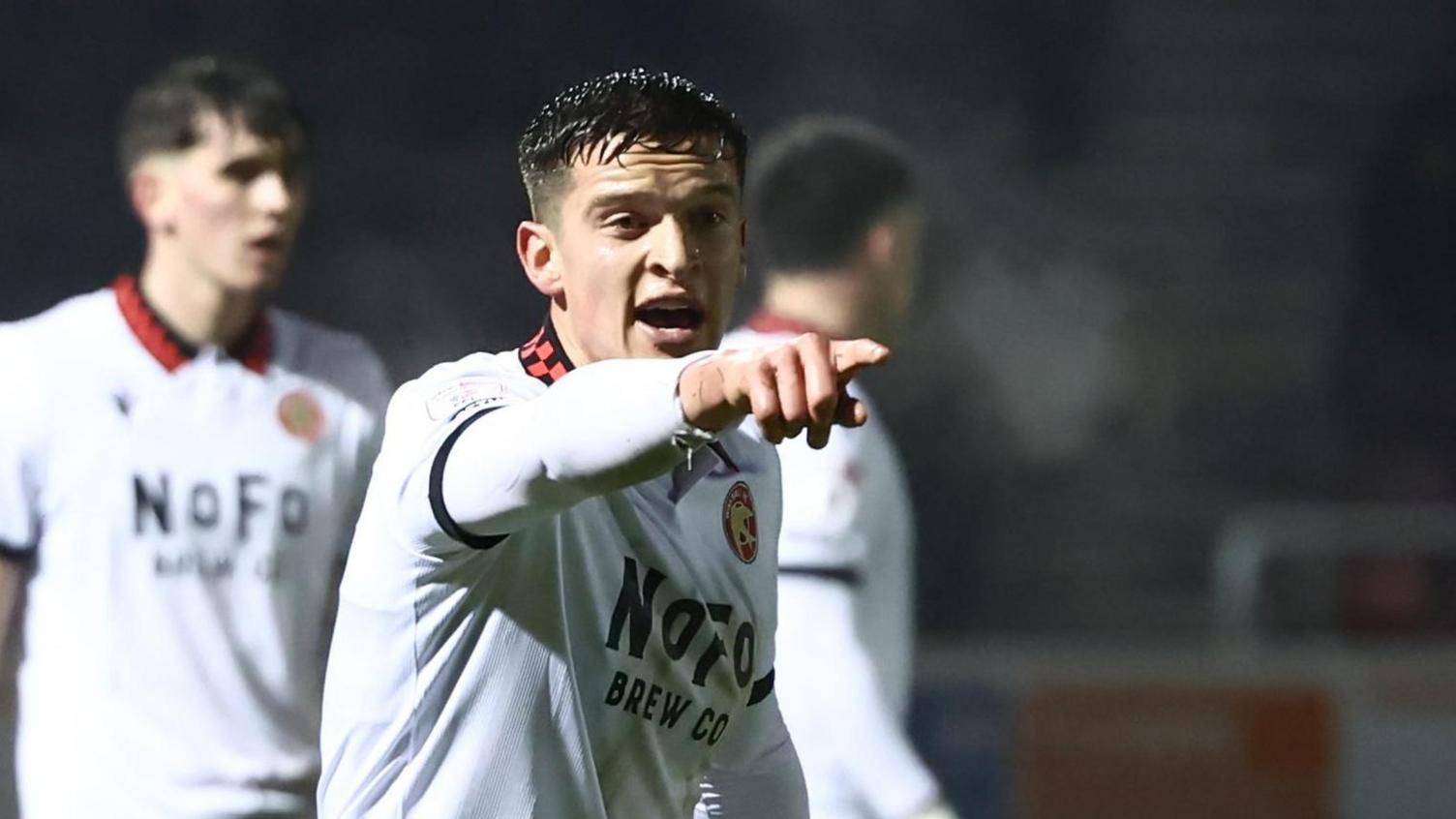 Harrison Burke points a directs a team-mate during a game for Walsall