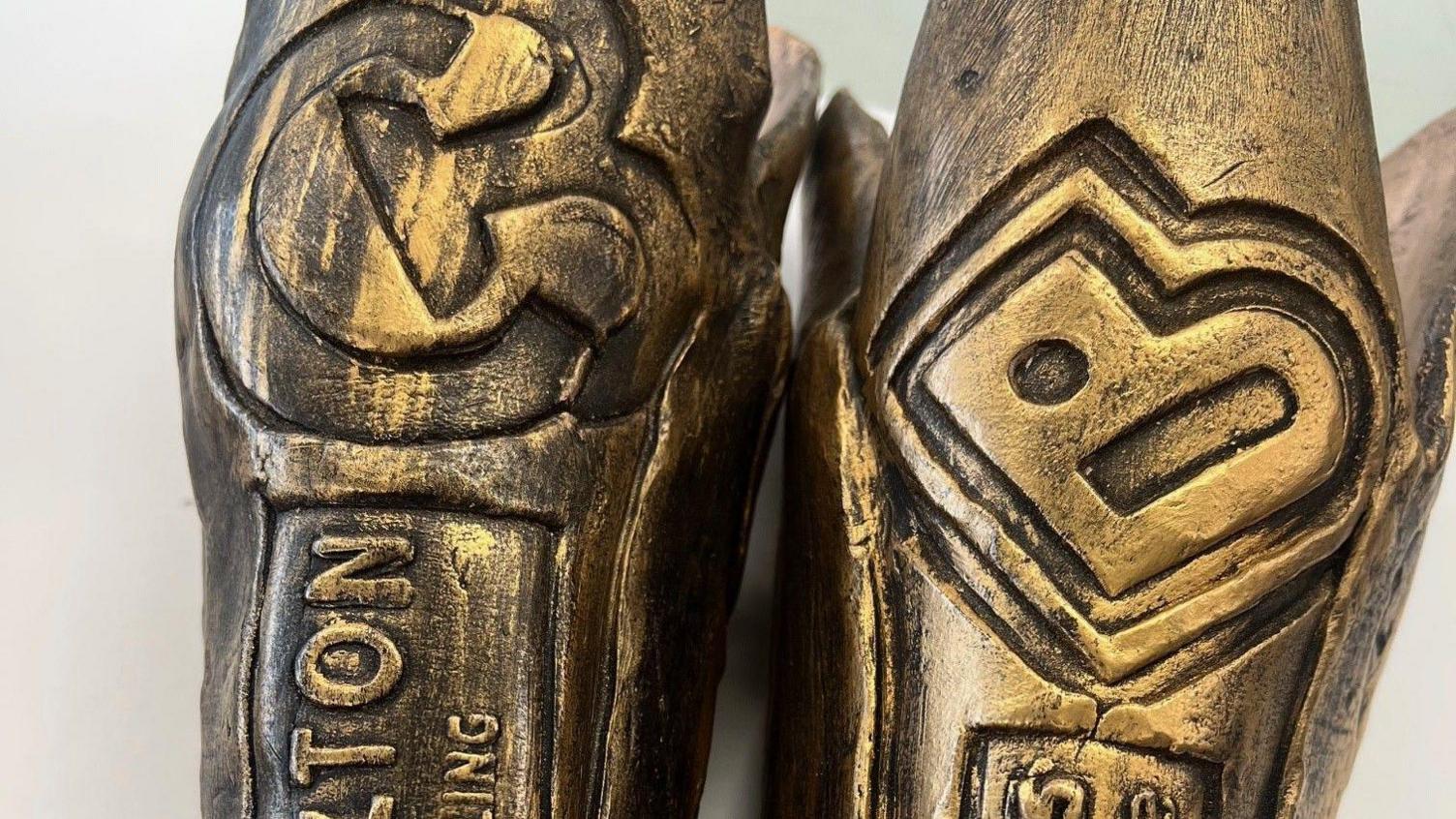 A close-up of two of the batons with the logos of Bradford City of Culture and Carlton Bolling school