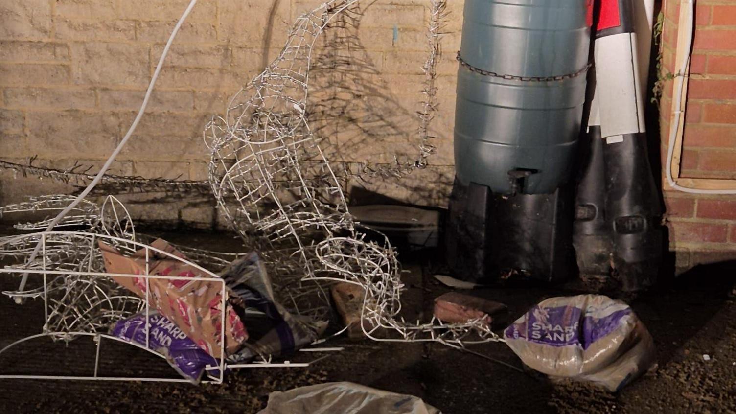 Christmas lights are strewn on the ground, surrounded by sandbags. 