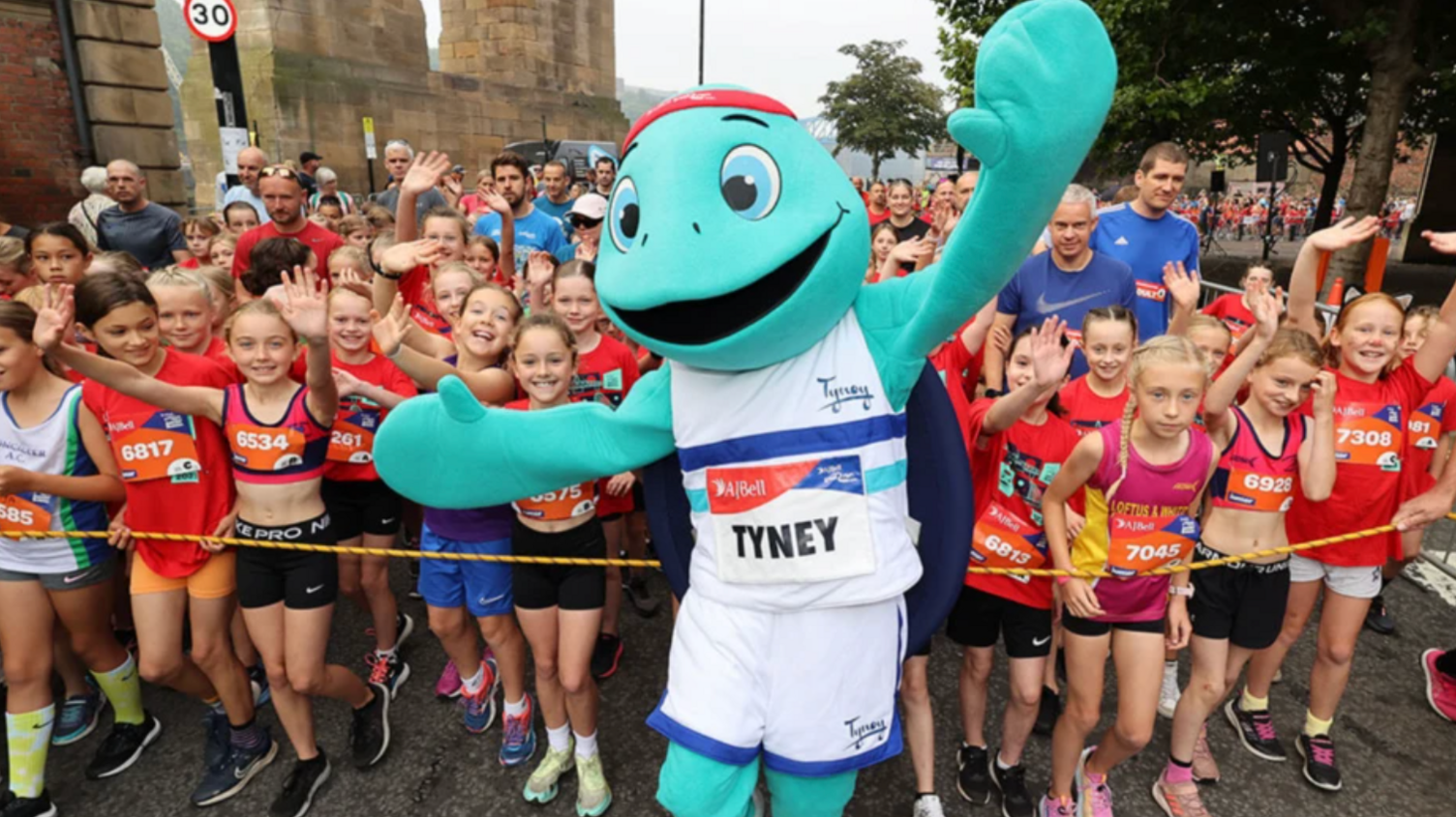 The junior and mini run mascot with children in the background.