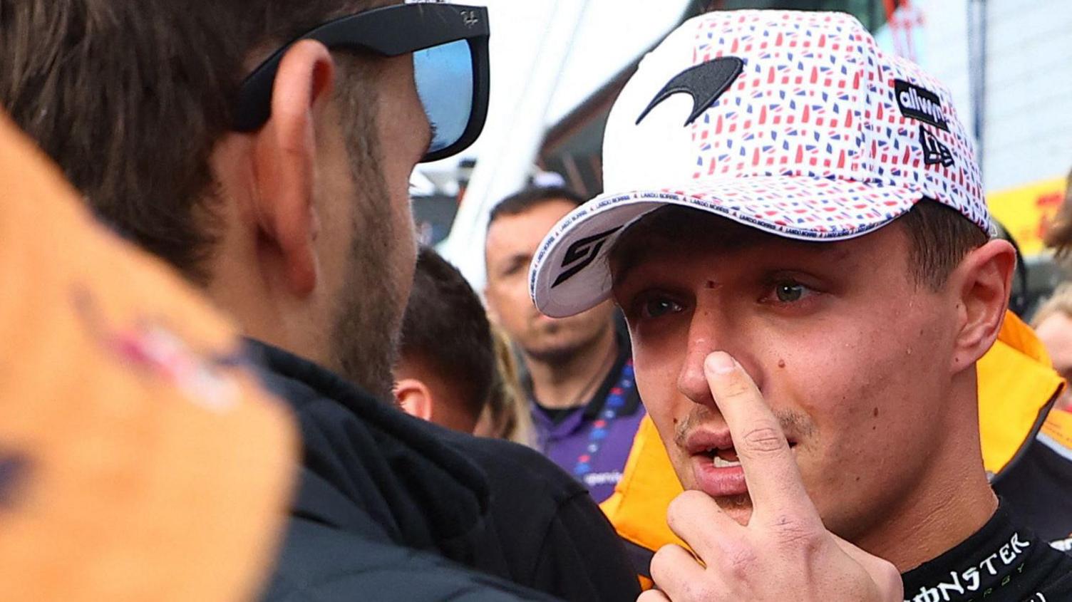 Lando Norris pointing at the injury on his nose