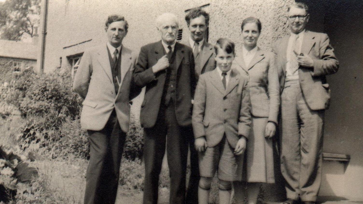 A group of people stand outside a youth hostel in the 1940s