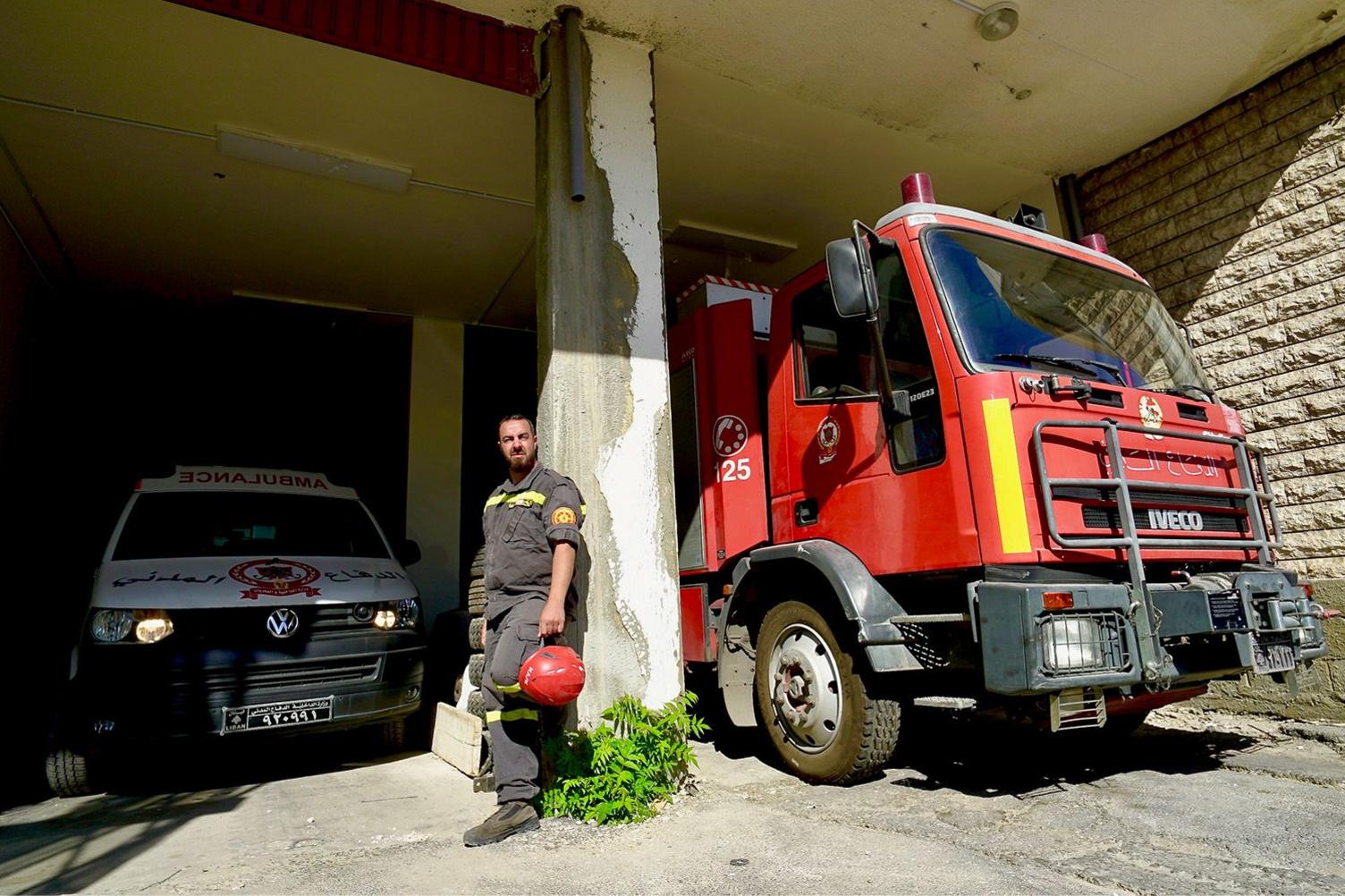 Samir El Chekieh standing next to fire engine and an ambulance.