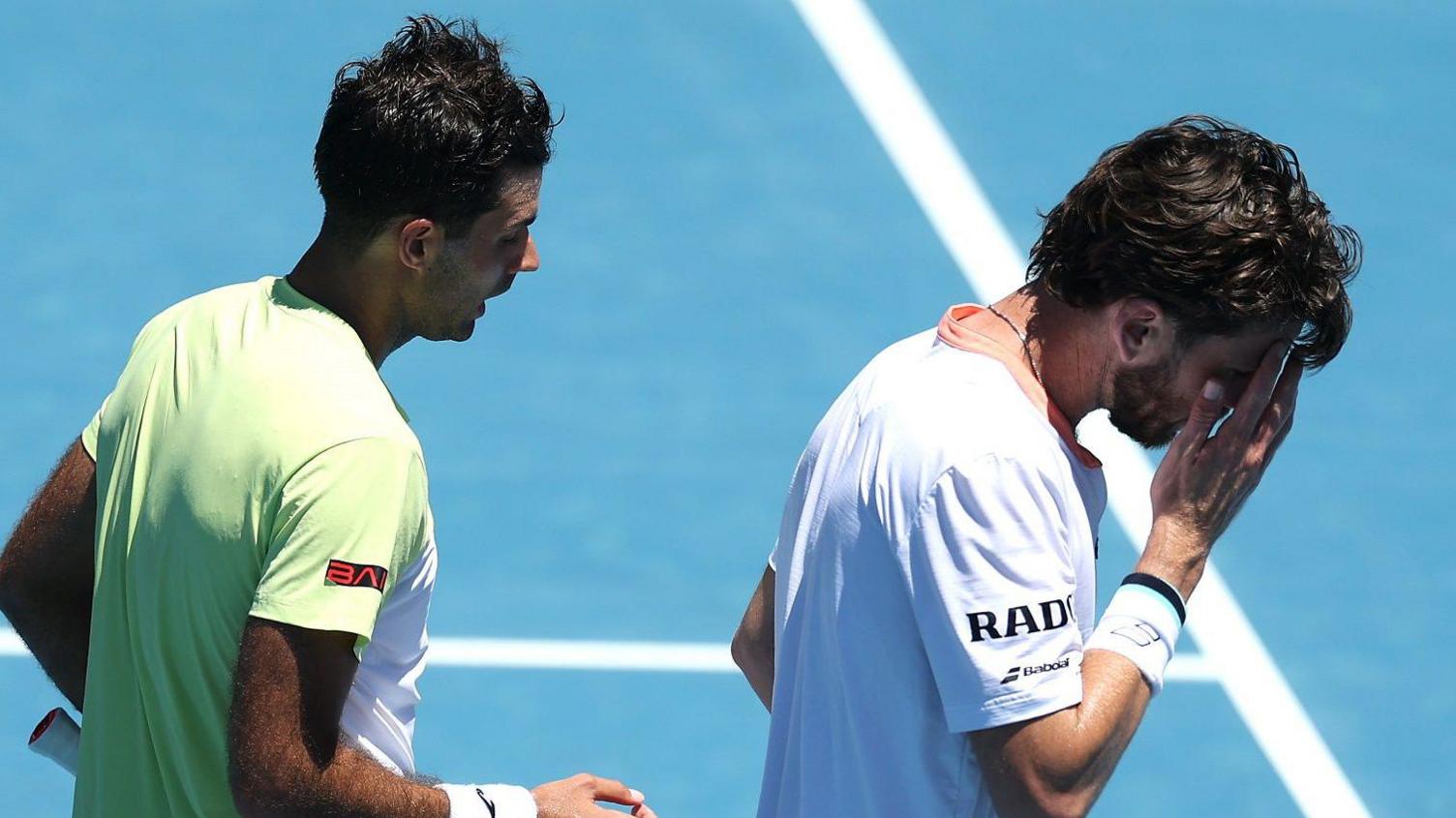 Cameron Norrie holds his hand to his face after losing in Auckland