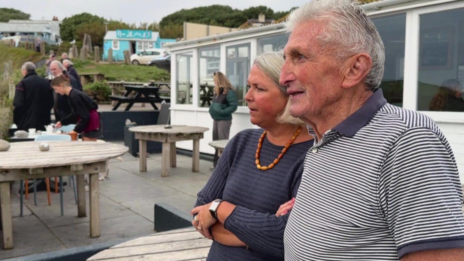 Man and daughter look out from café 