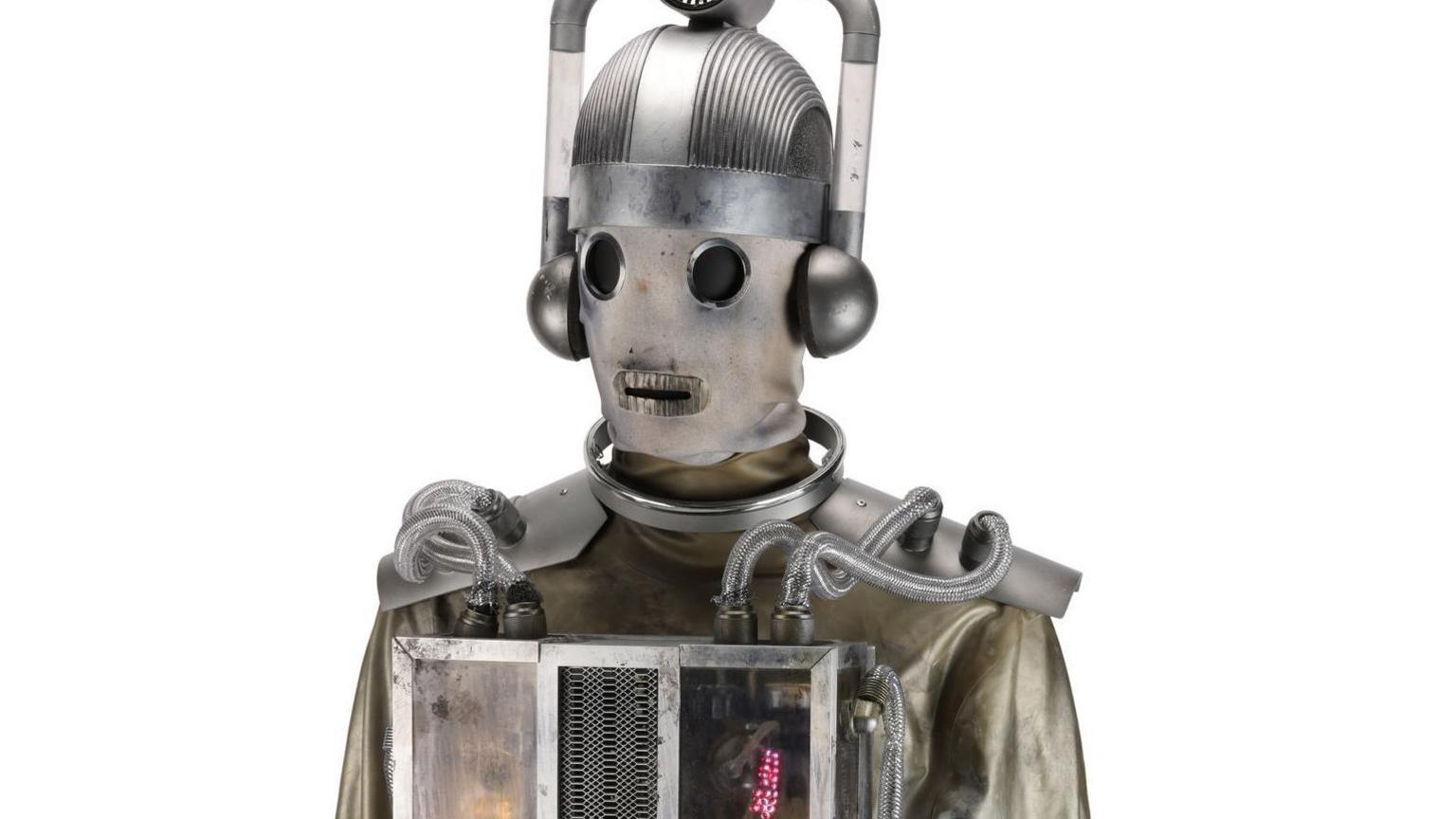 A Mondasian Cyberman which looks vaguely steampunk with a material like face. It has large silver headpiece and light-up box on its chest