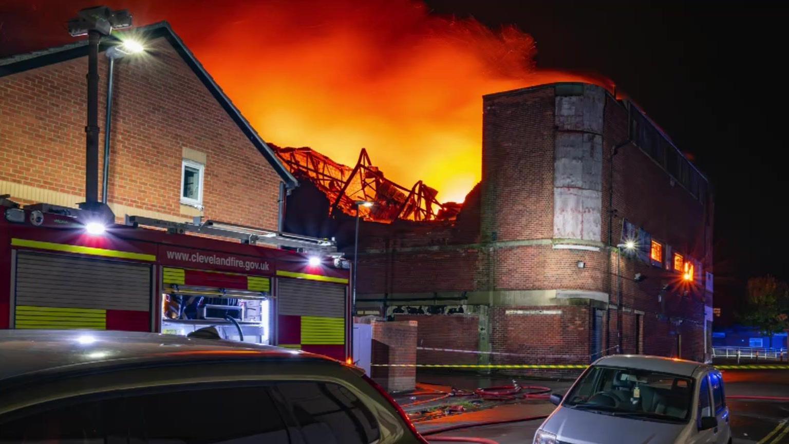 A large fire at the former cinema, which is a tall brick building. A Cleveland fire truck is parked outside and a yellow cordon has been placed around the buildings.