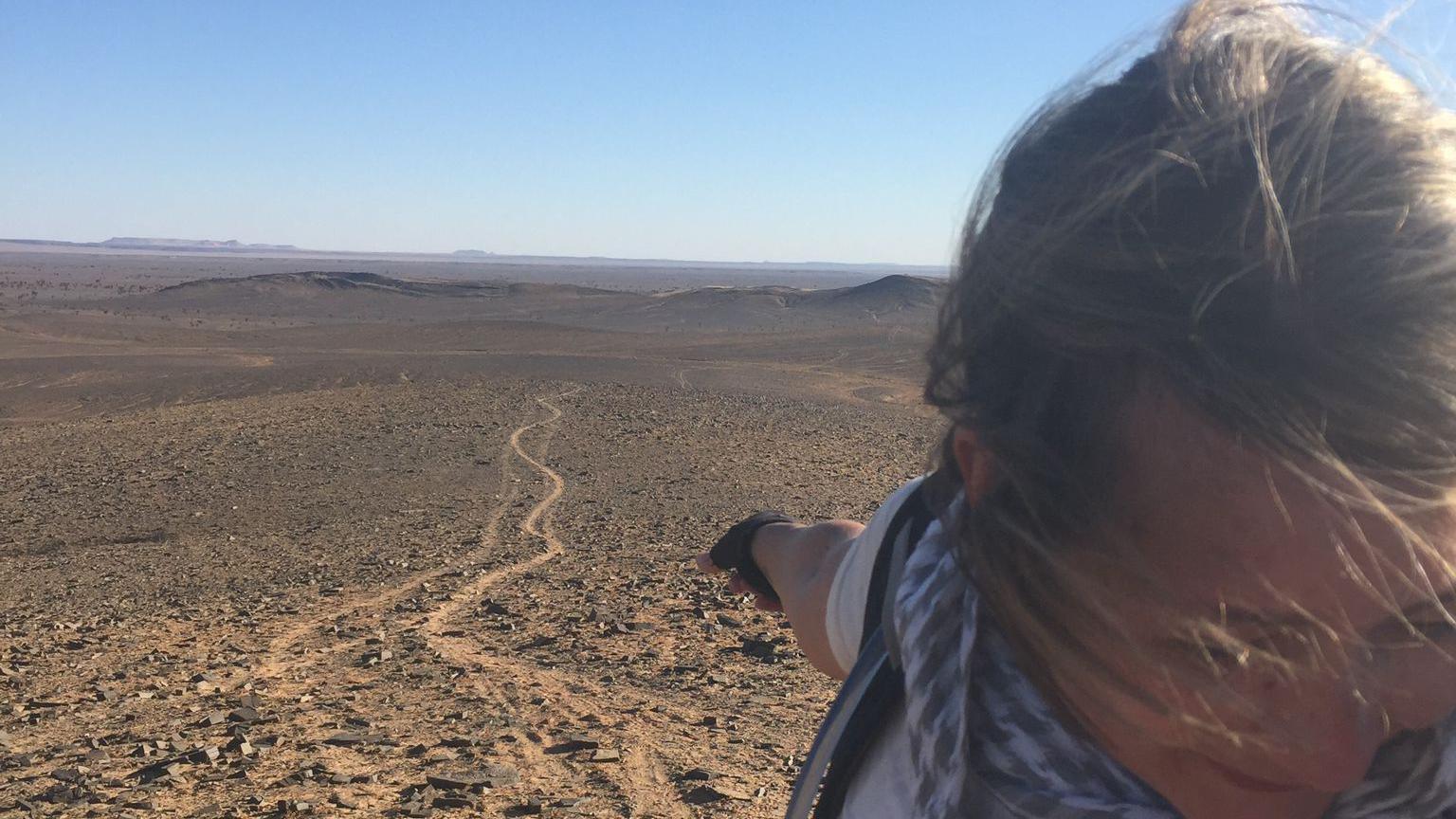 Nikki Gilmour facing against the wind in the Sahara Desert