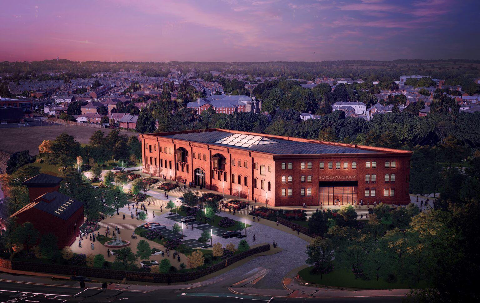 Artist's impression of how a goods yard could look as it is renovated into new homes. It's a large red brick building pictured at night, with an illuminated glass-fronted entrance and heavy shrubbery lining an entrance road. The windows to the building are small and have a silver sheen as they catch the reflection of the moon.