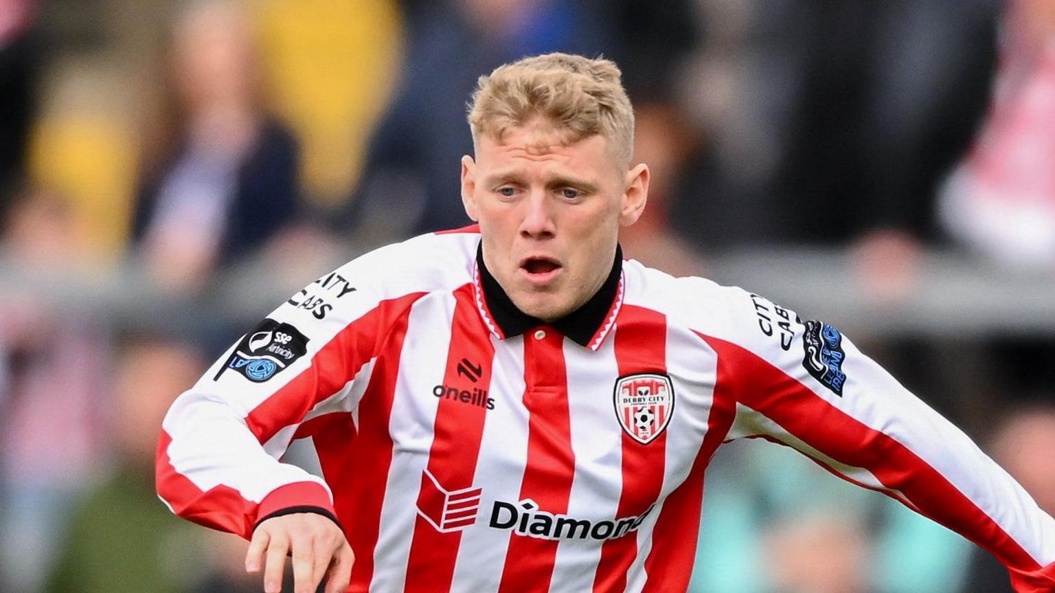 Josh Thomas playing for Derry City in a red-and-white striped kit