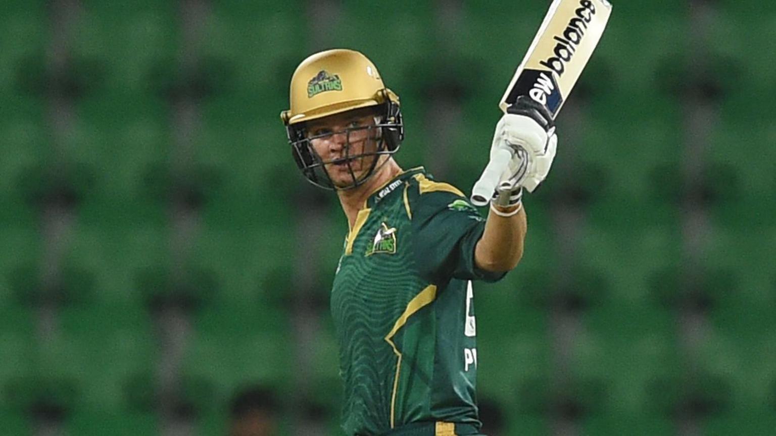 Josh Philippe in green Multan Sultans kit and gold helmet raises bat towards crowd