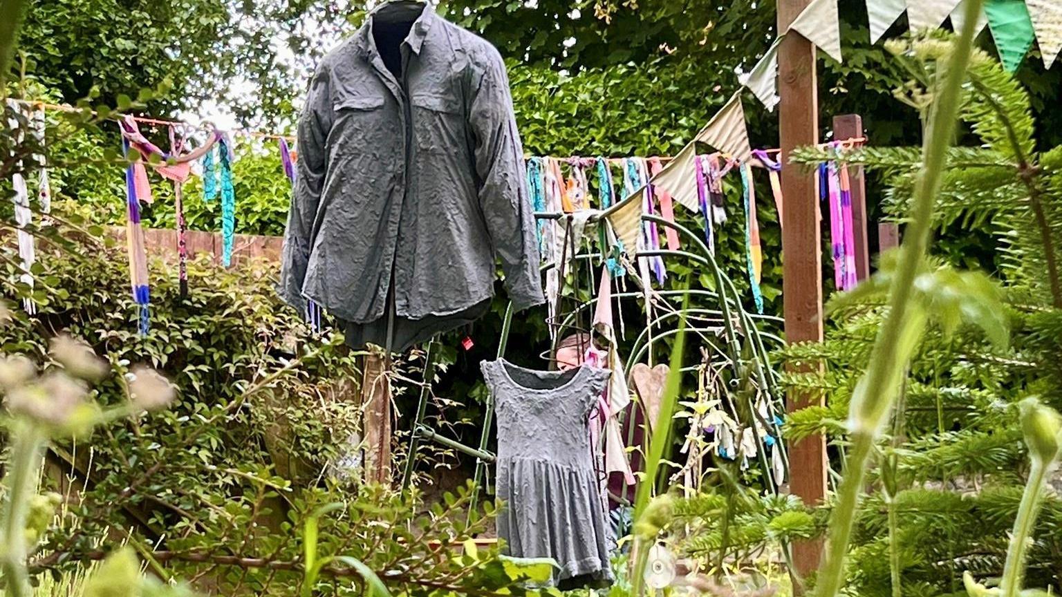 Some old clothes hanging in a garden - one of the exhibits in the art trail 