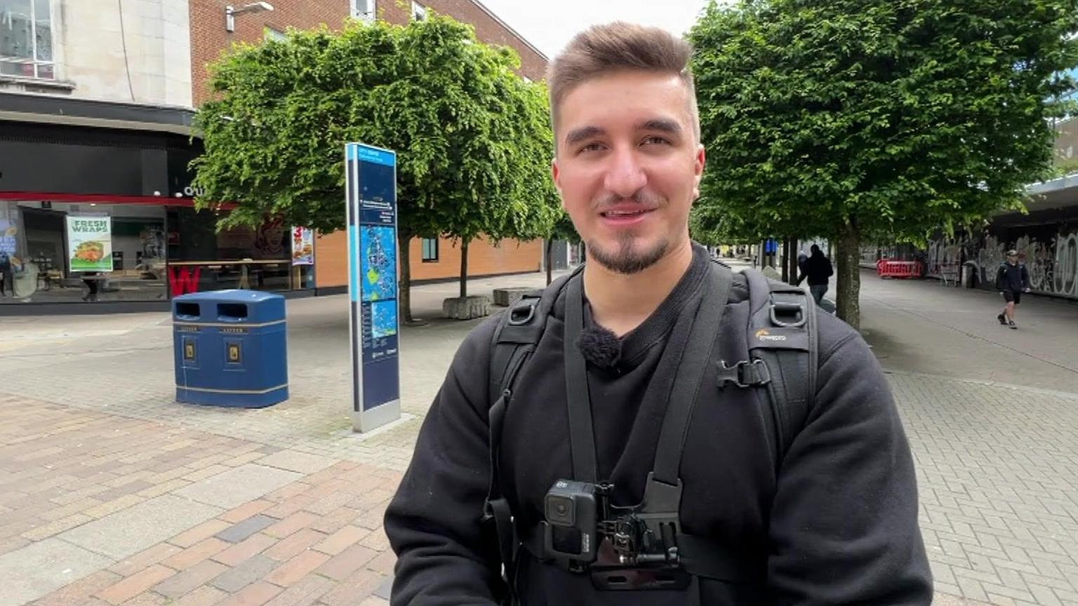 Jamie O'Neill standing on a Portsmouth shopping street with a camera round his neck