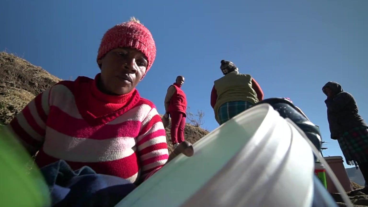 A woman collecting water in a bucket