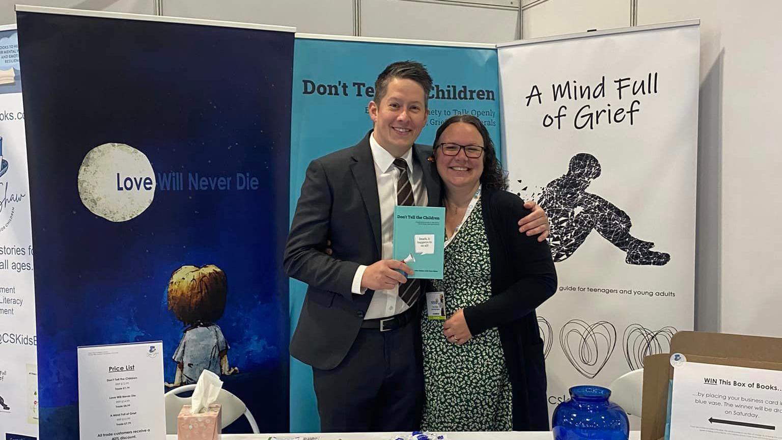 John Adams and Clare Shaw holding their book