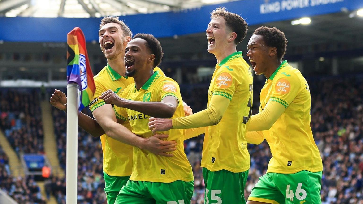 Ali Ahmed is hugged by two Norwich team-mates after scoring against Leicester City