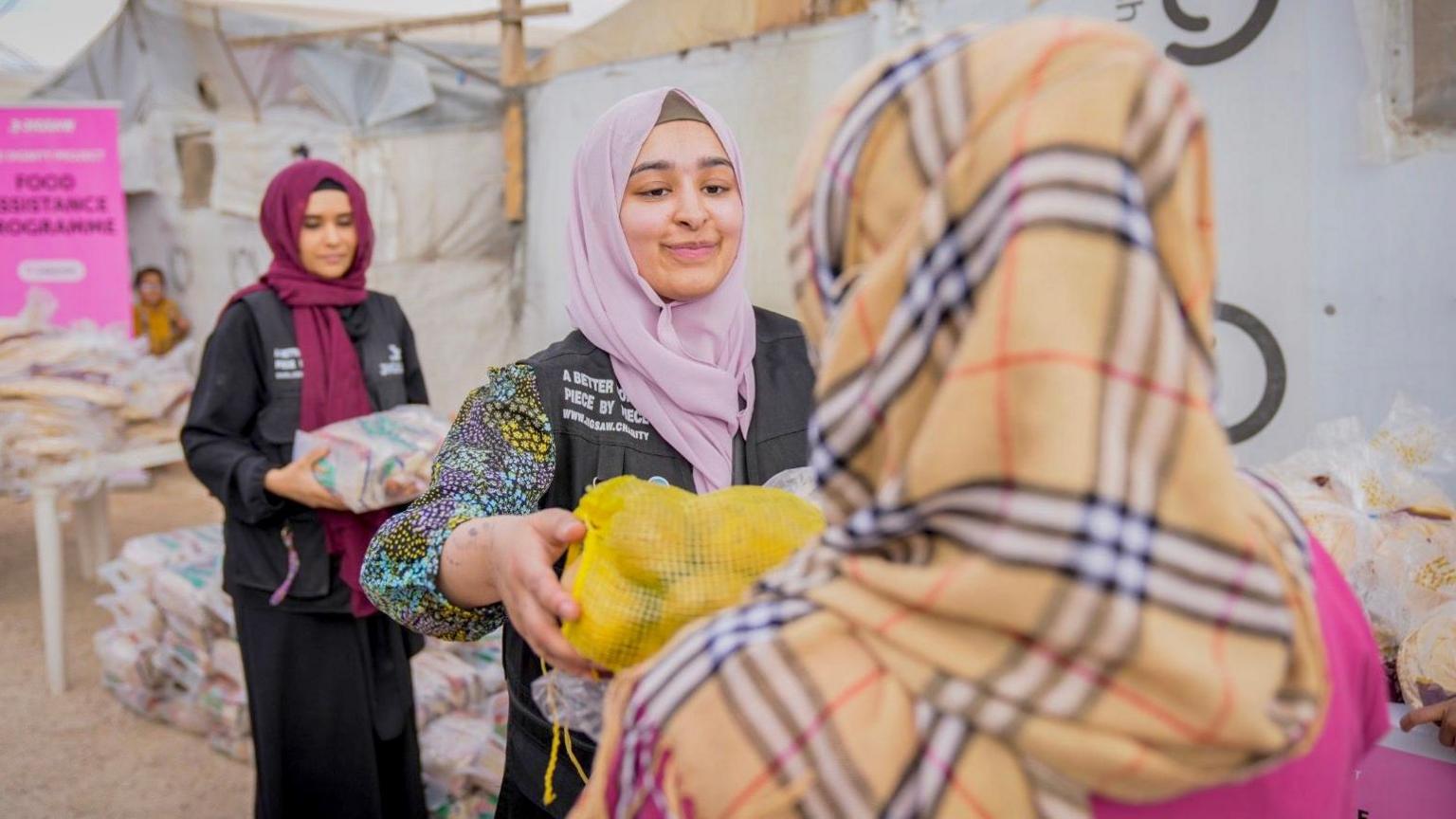 Laya giving a parcel to another woman