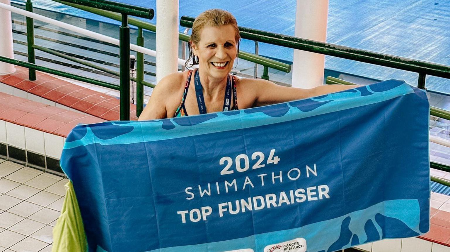 Julie standing with her competition towel without swim cap