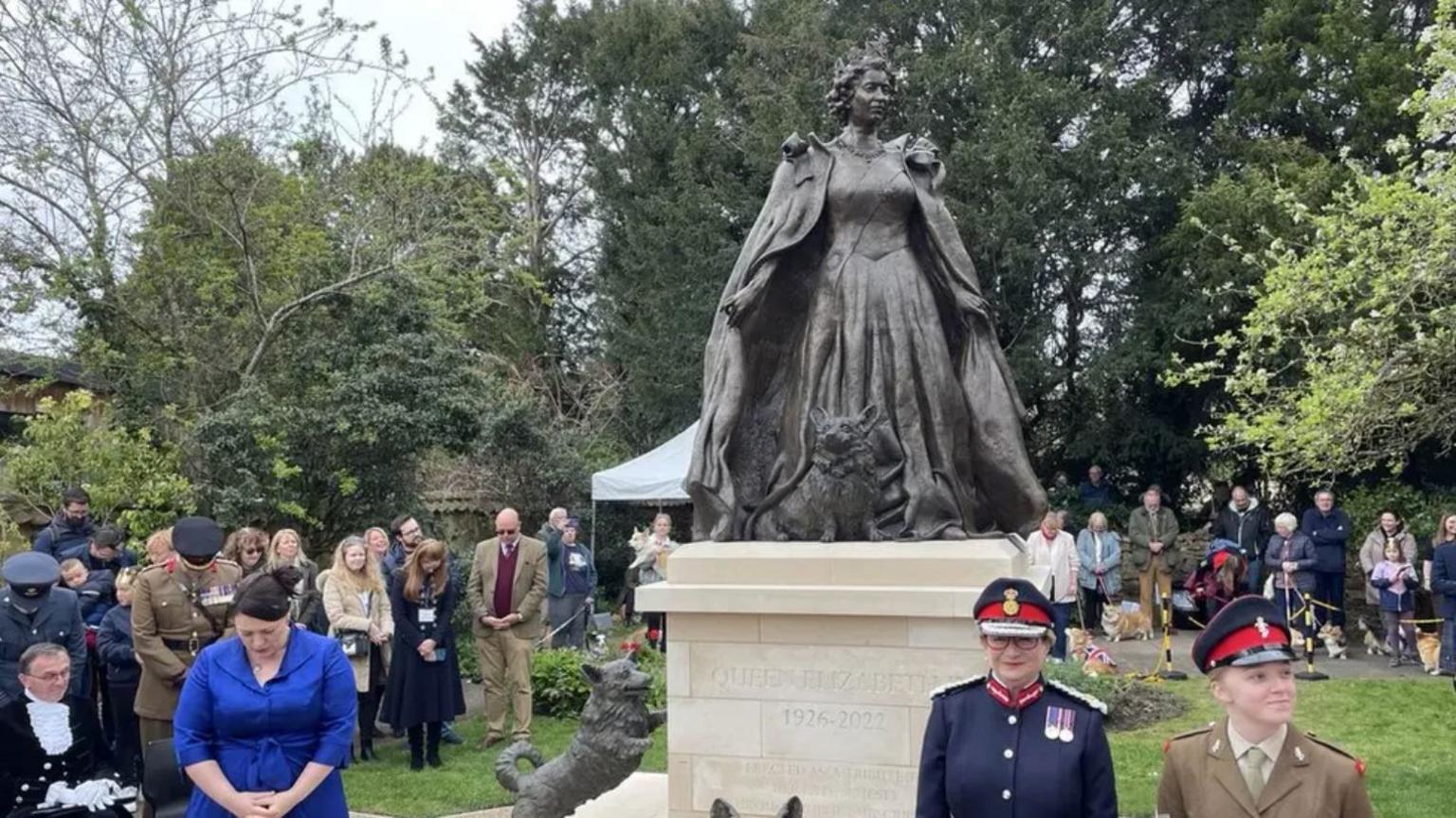 a statue of Queen Elizabeth II with statues of her corgis