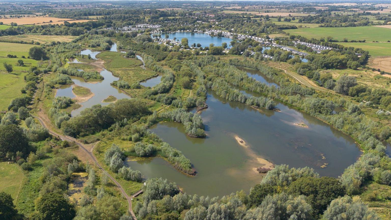 Flood plain and forest see from above with houses on the edge of the large wetland area.