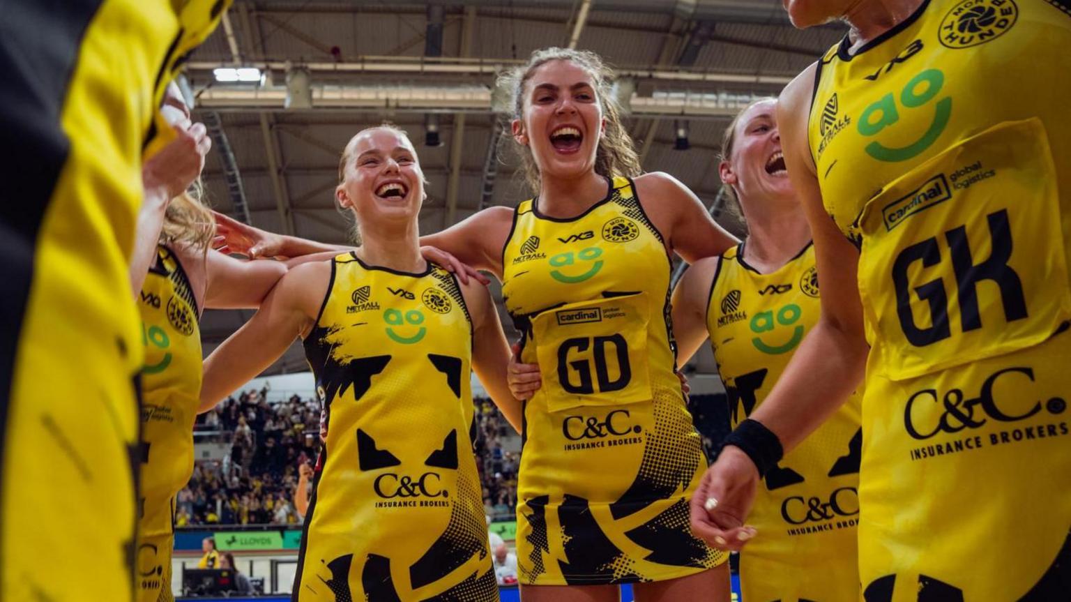 Manchester Thunder netball team in a celebratory huddle after a game.
