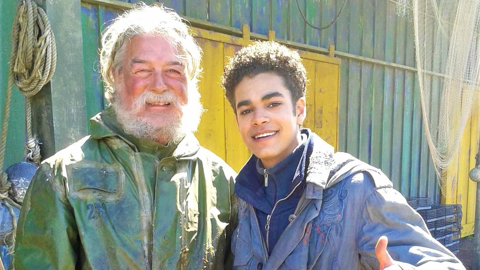 Nick on the left with a scraggly beard and green coat, next to Will Parry on the right, who is wearing a blue coat, and putting his thumb up at the camera.