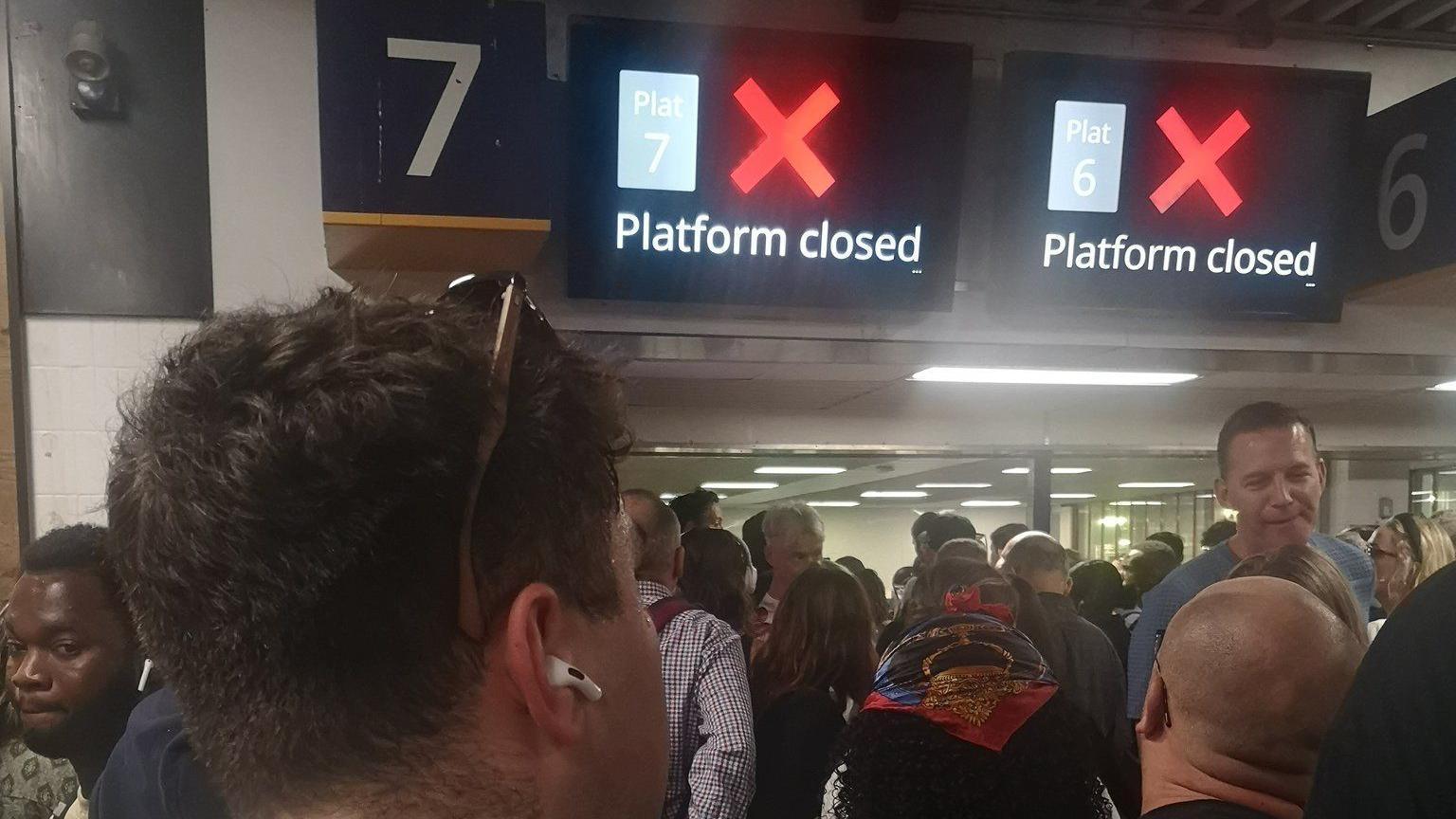 Crowds of people at Euston station under a sign saying "platform closed" 