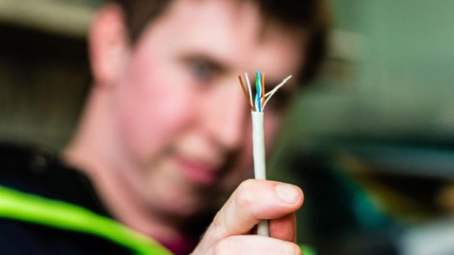 A man holds a computer cable 