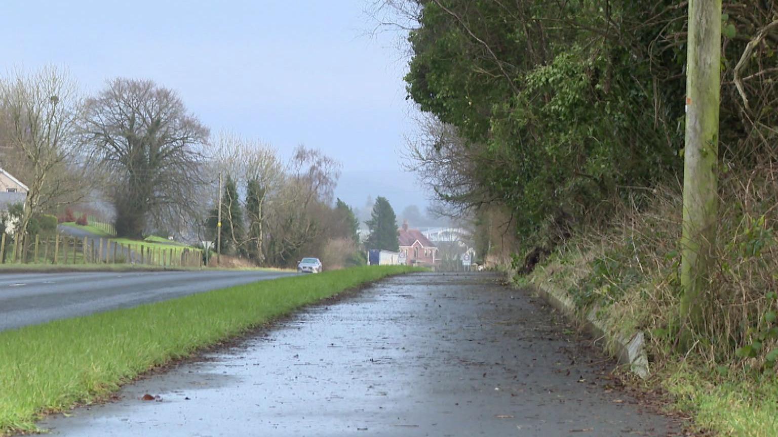 A wide stretch of footpath on a country road