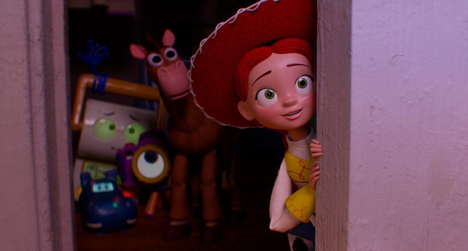 Jessie from Toy Story peaks from behind a door with several other toys behind her.