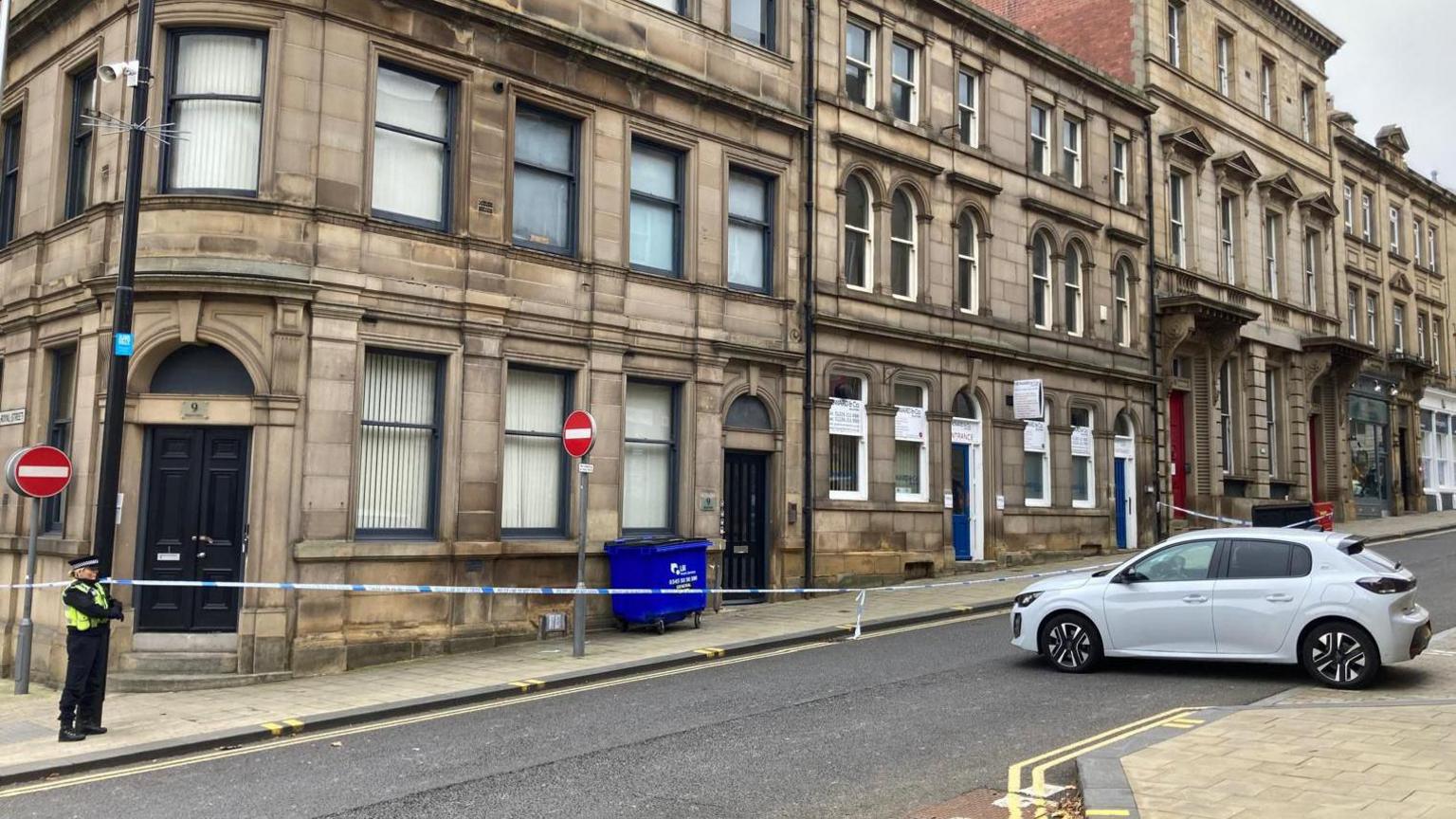 Regent Street in Barnsley after a stabbing on October 25. A police officer is stood next to an area cordoned off with police tape.