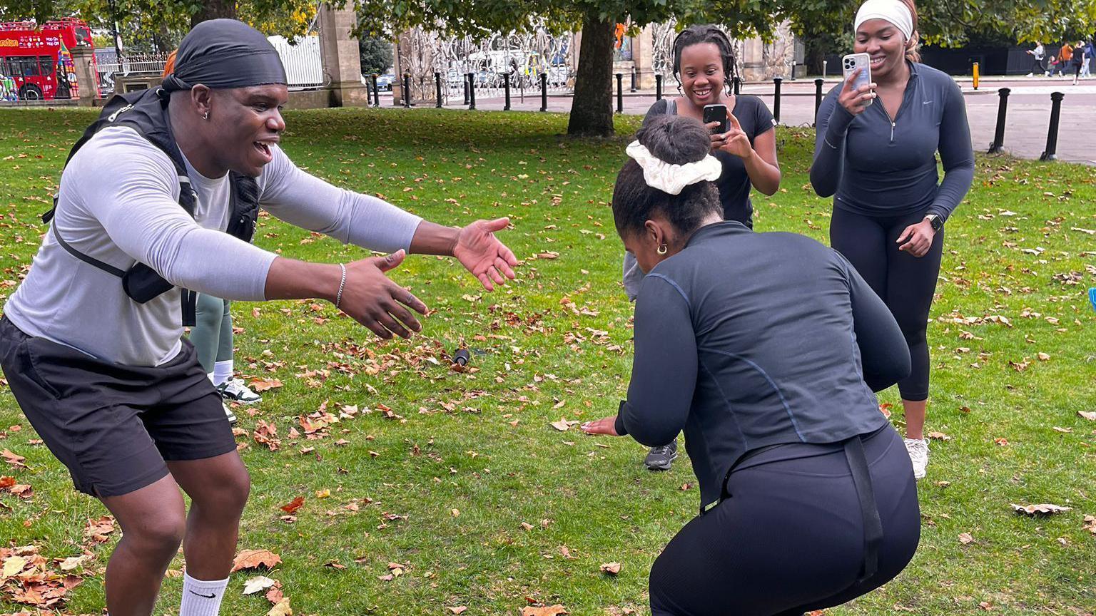 A man and a woman wearing running gear dance in Hyde Park