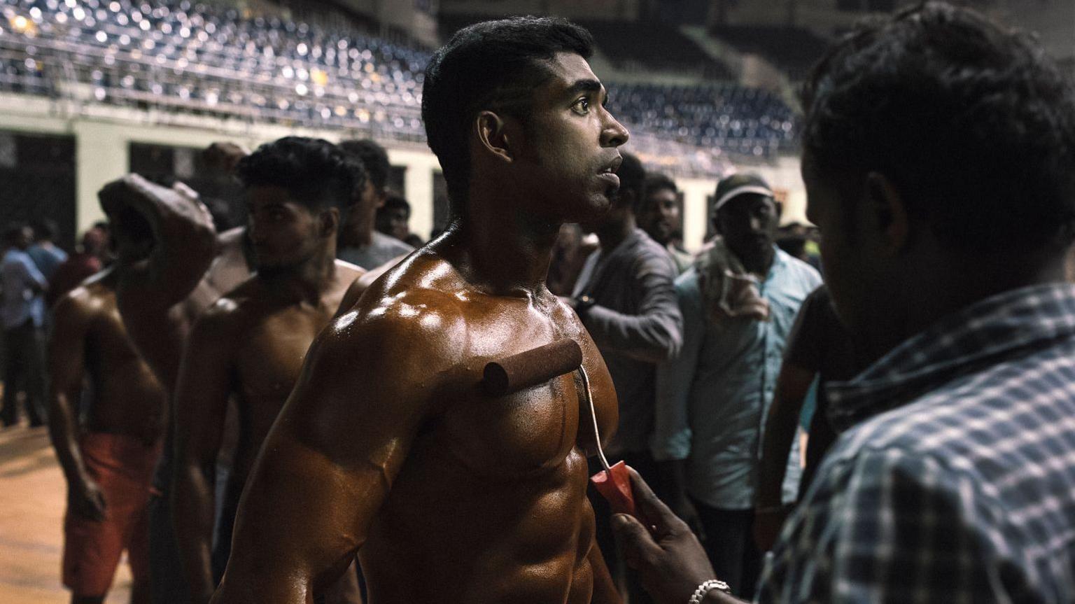 A bodybuilder waits in line