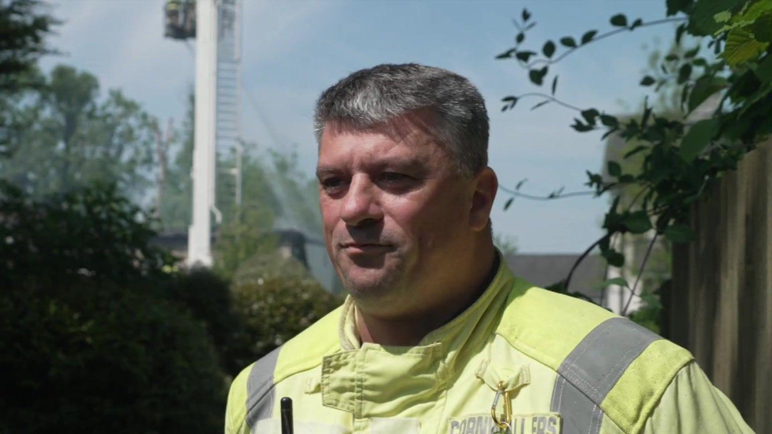 Jason Doney wearing a high viz yellow jacket. He is standing in front of the scene and has short grey hair. He is clean shaven.