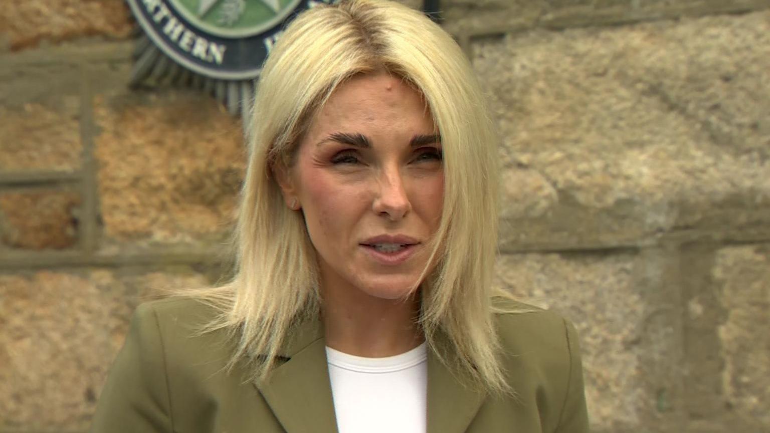 DCI Kerrie Foreman in white shirt and green blazer. She has blonde hair.