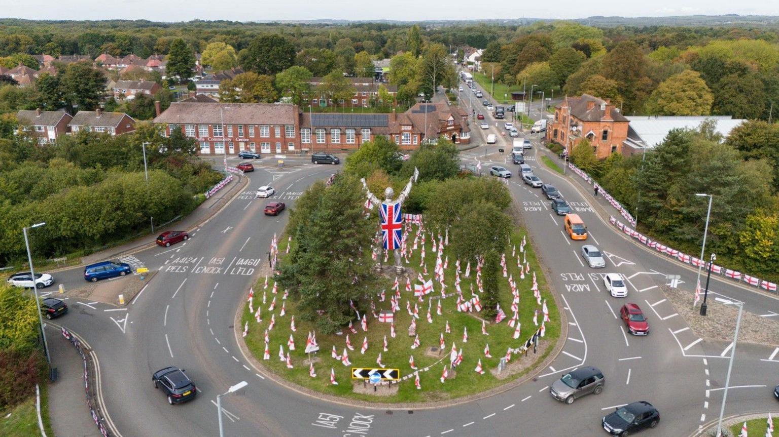An aerial view of a roundabout containing dozens of flags.